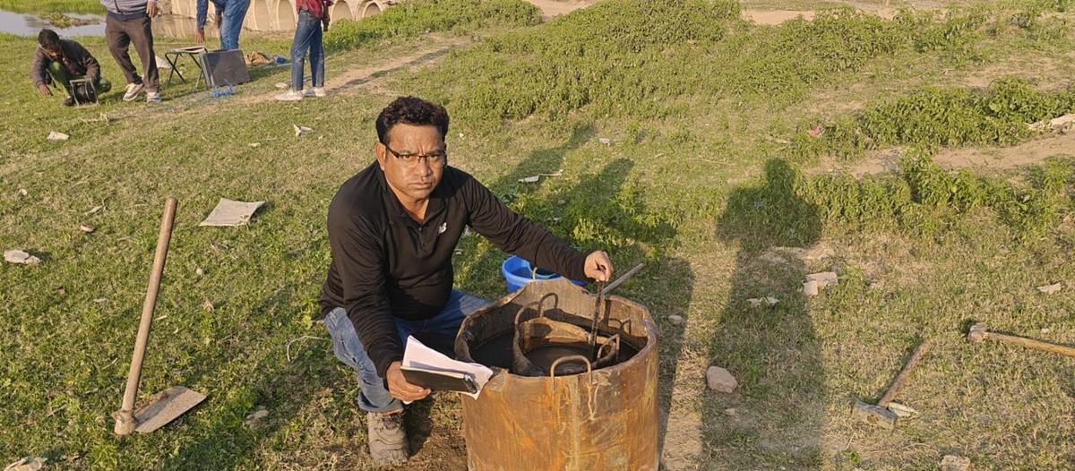 Engineer with a test ring during a field survey beside a drain