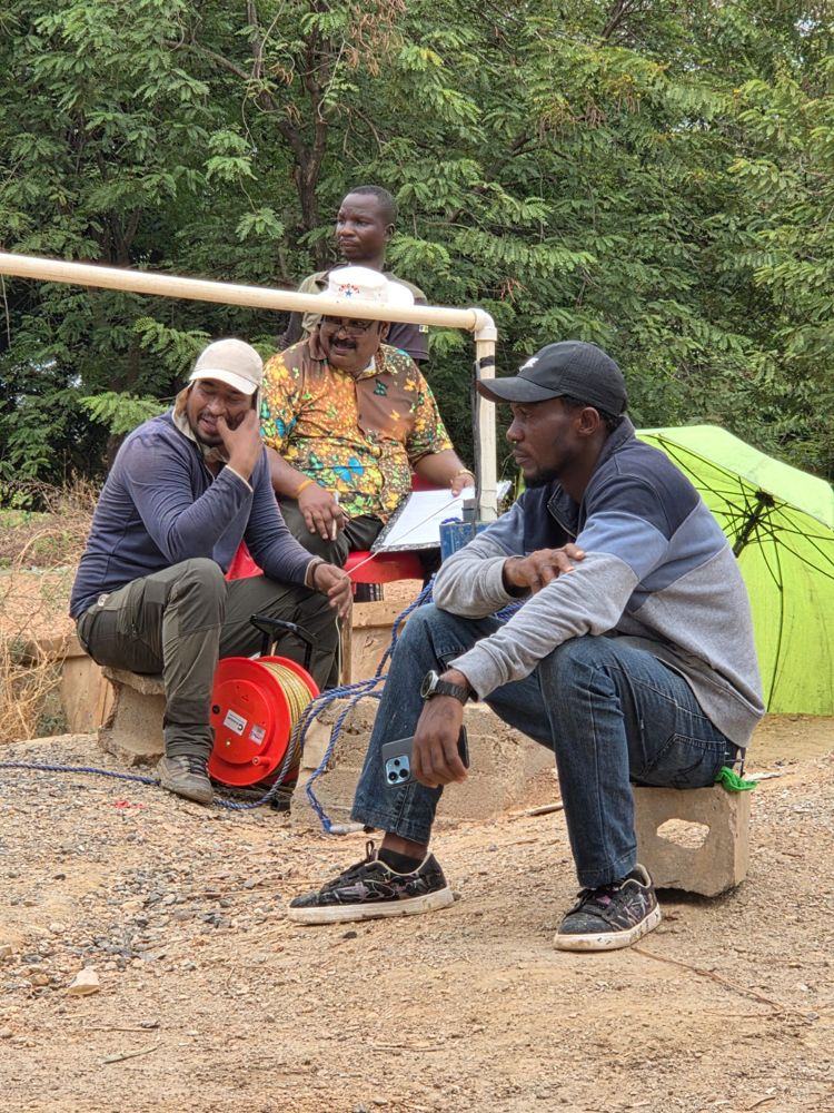Hydrogeologists recording a pumping test with a water level sounder